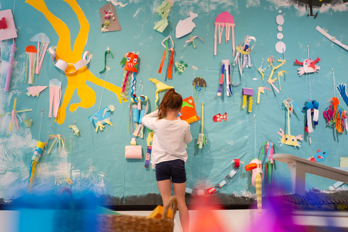 Colourful creations made by students cover the wall.